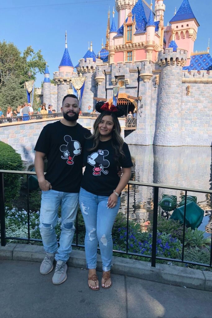 Black Kissing Mickey & Minnie Graphic T Shirts + Light Wash Distressed Jeans + Grey Sneakers & Brown Flat Sandals