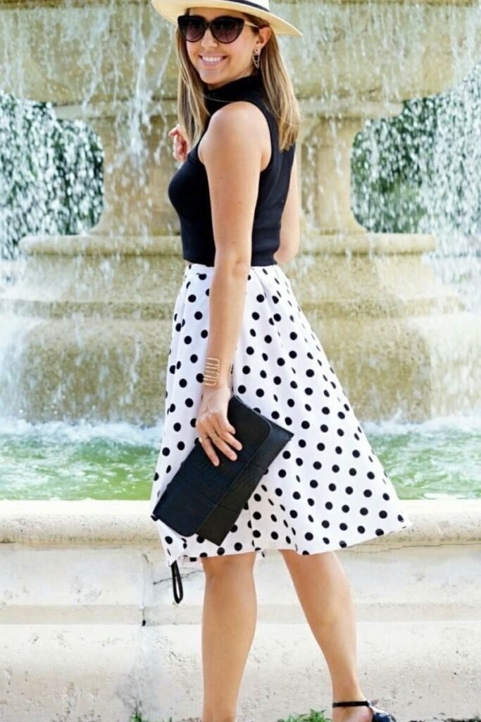 Black Sleeveless Mock Neck Top + Polka Dot Belted Skirt + Straw Hat + Black Clutch