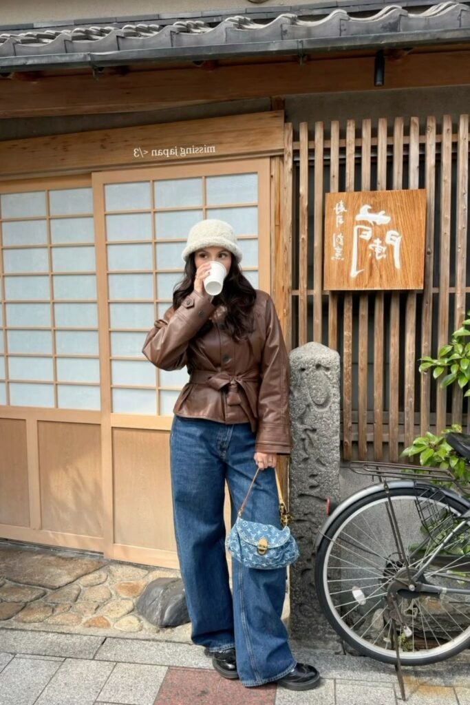 Brown Leather Tied Jacket + Wide Leg Blue Jeans + Cream Bucket Hat + Black Shoes