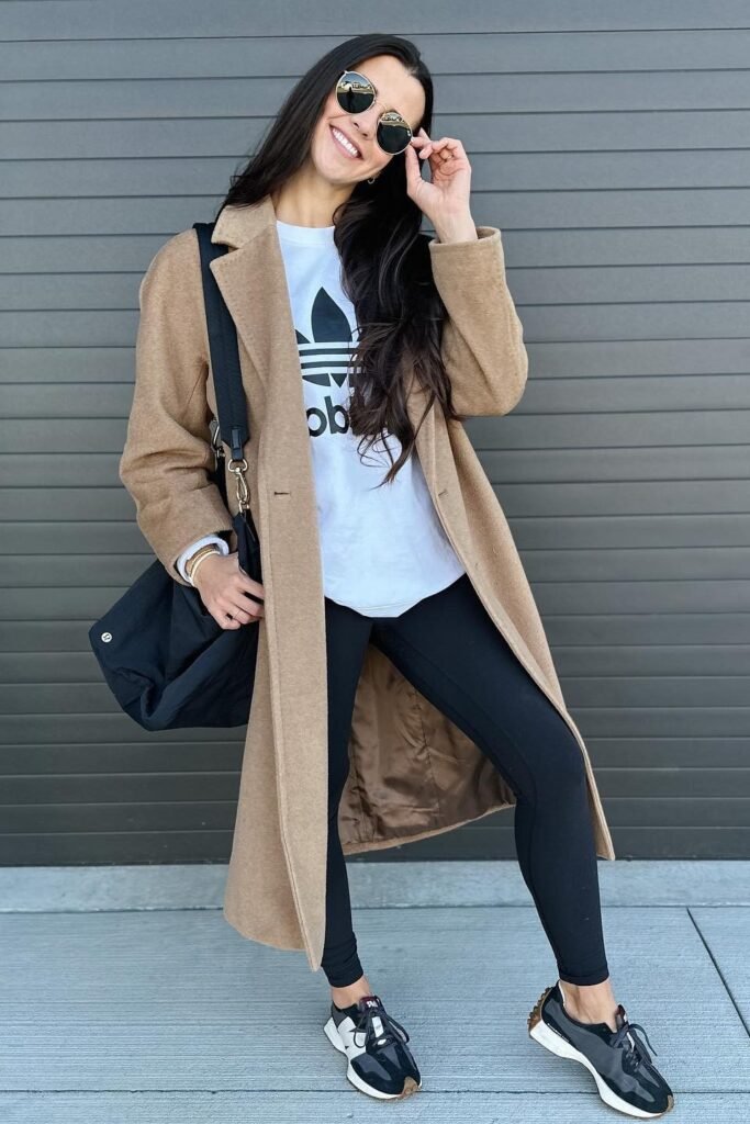 Camel Long Coat + White Graphic Long Sleeve + Black Leggings + Black and White Sneakers