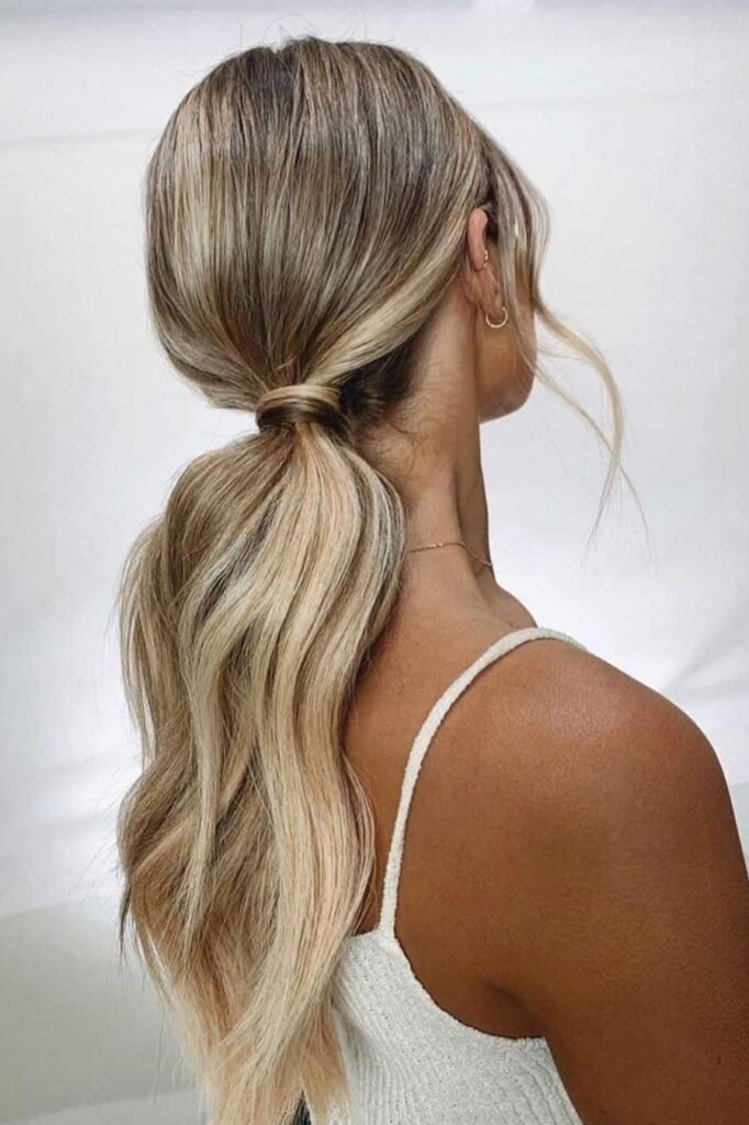Low Textured Ponytail with Wavy Lengths and a Wrapped Hair Base