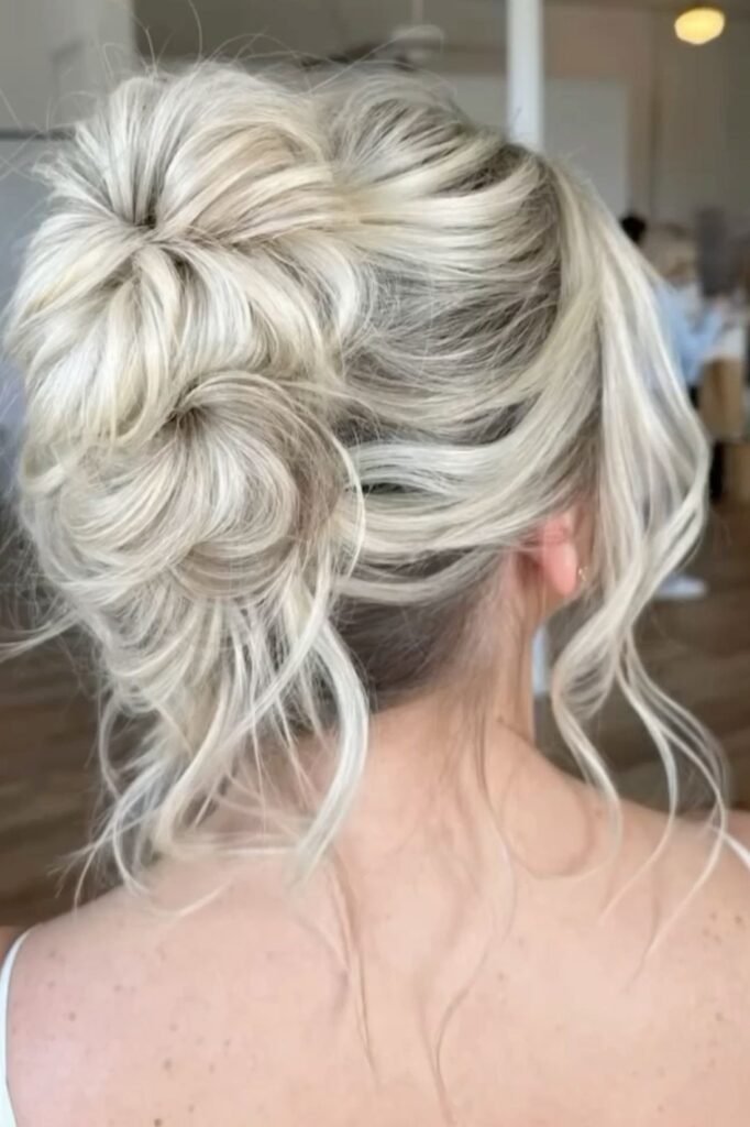 Messy High Updo with Loose Platinum Blonde Tendrils