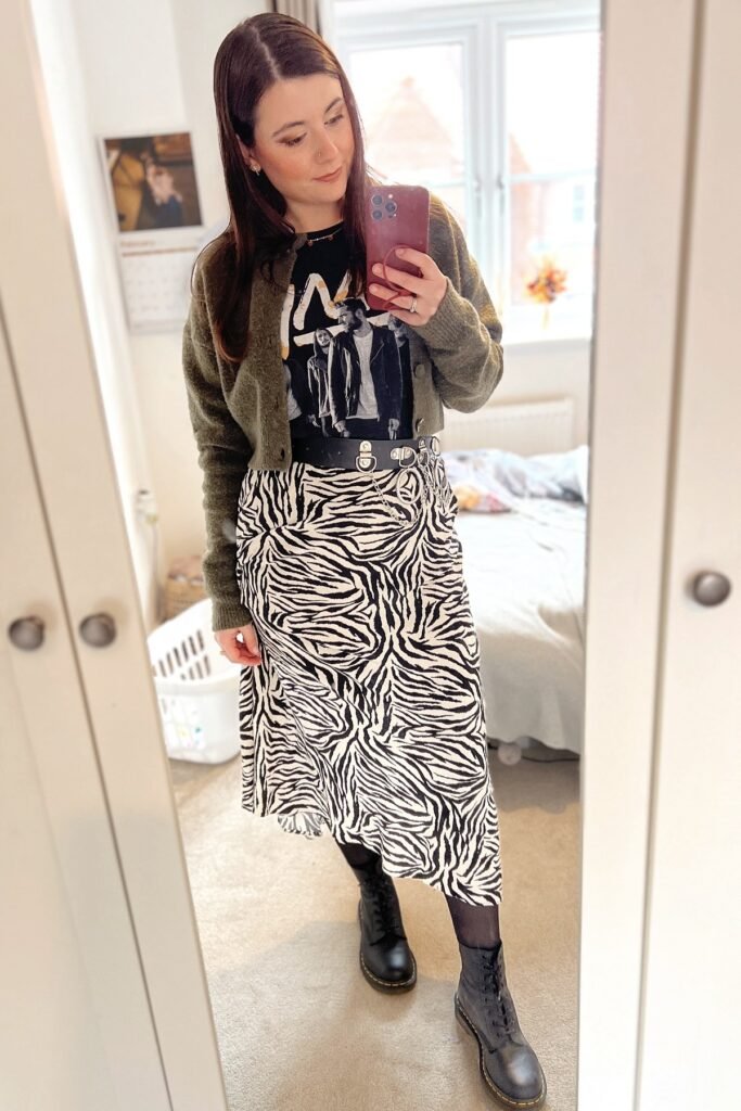 Olive Green Cardigan + Graphic T Shirt + Zebra Print Skirt + Black Lace Up Boots