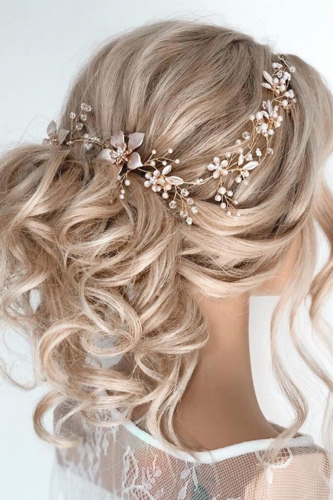 Romance-Inspired Curly Low Updo with a Floral Pearl Headpiece