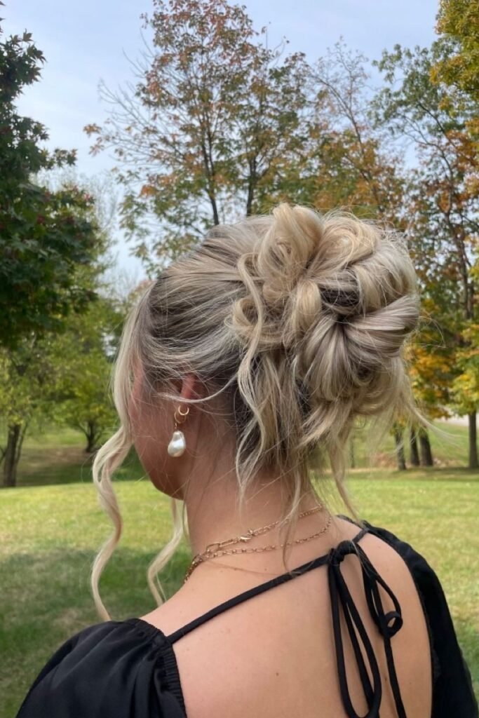 Voluminous Textured High Bun with Curly Tendrils