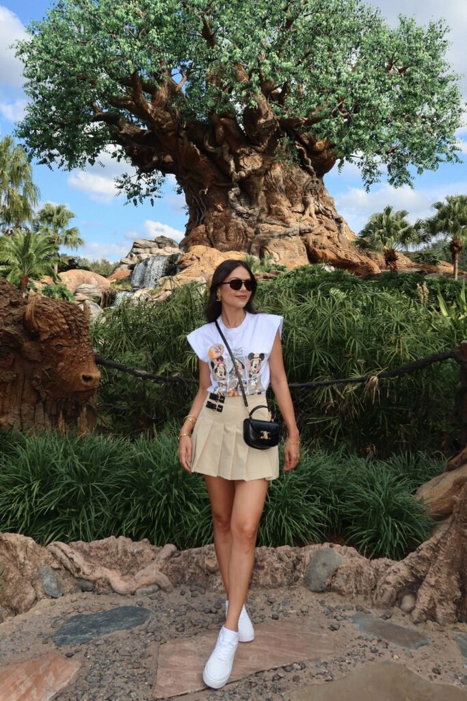 White Muscle Tee + Beige Pleated Mini Skirt + White High Top Sneakers