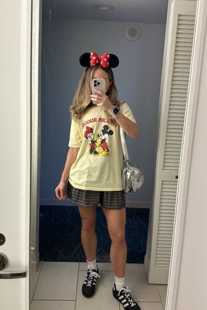 Yellow Bonjour Mickey Graphic Tee + Plaid Pleated Mini Skirt + Black and White Sneakers with Ruffled Socks