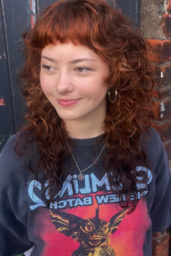 22. Curly Auburn Shag with Micro Bangs
