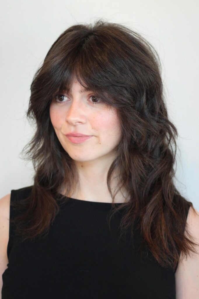 25. Dark Wavy Shag with Thick Bangs