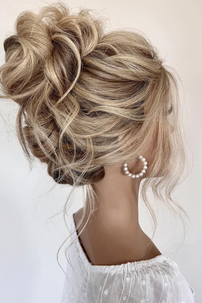Romantic High Messy Bun with Loose Face-Framing Strands
