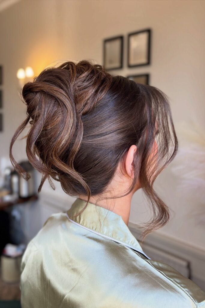 Sophisticated Brunette Updo with Highlight Dimension and Side-Swept Waves