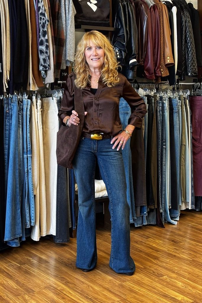 A chocolate satin blouse and gold belt bring retro glam to classic bootcut jeans.