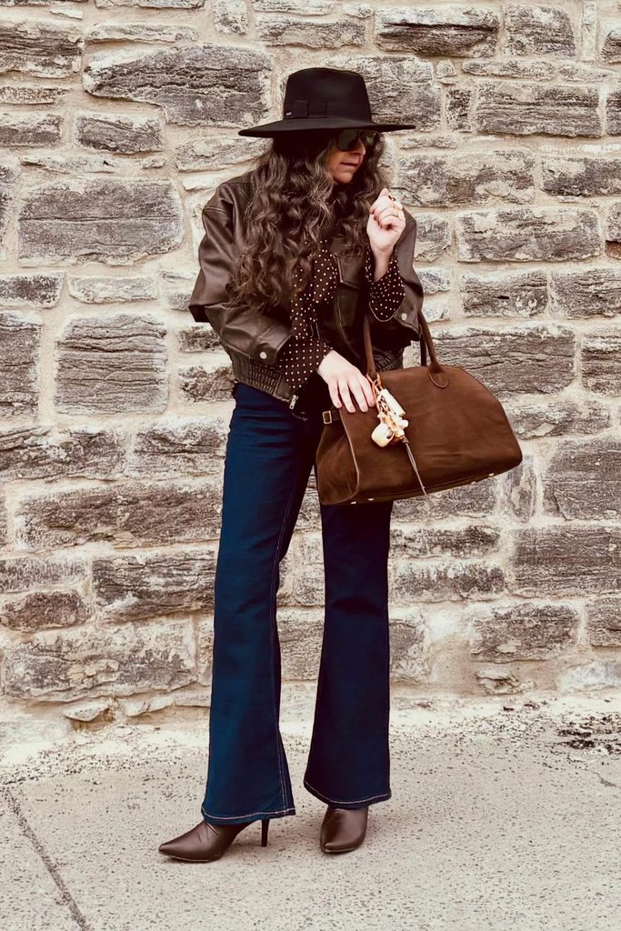 A polka dot blouse peeking from an oversized leather jacket brings a retro rock twist.